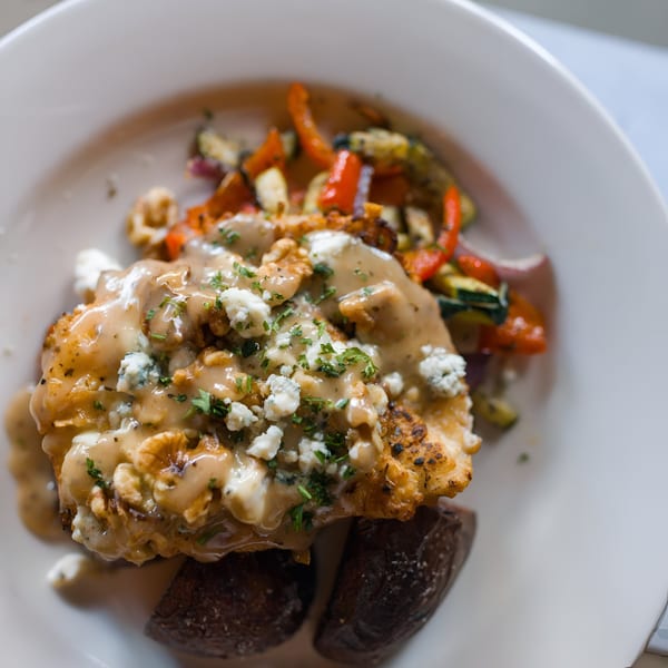 Italian Kitchen's chicken dish with creamy sauce, crumbled cheese, walnuts, and roasted vegetables.